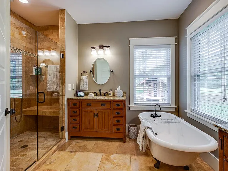 Master bath with claw-foot tub, large shower, two sinks, and separate toilet room.