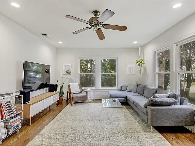 Bright Open Concept Living Room with Large Windows, Ceiling Fan, Hardwood Floors