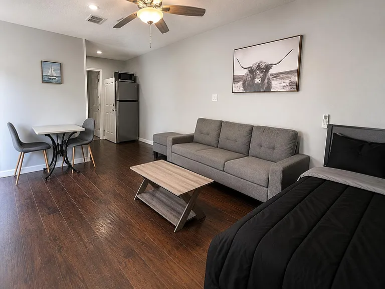 Versatile studio-style living area with a comfortable seating zone, dining nook, and convenient in-room mini fridge.