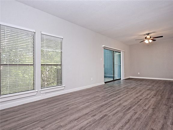 Living room view showing 1st floor balcony entrance to overlook greenbelt.