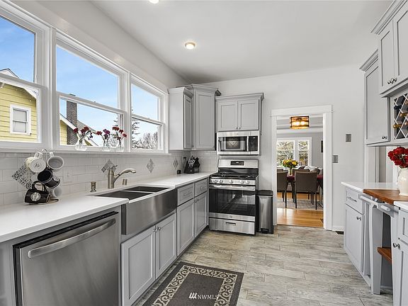 Kitchen remodeled with gorgeous quartz counters, large, stainless steel, Farmhouse sink, and solid wood, kitchen cabinets.