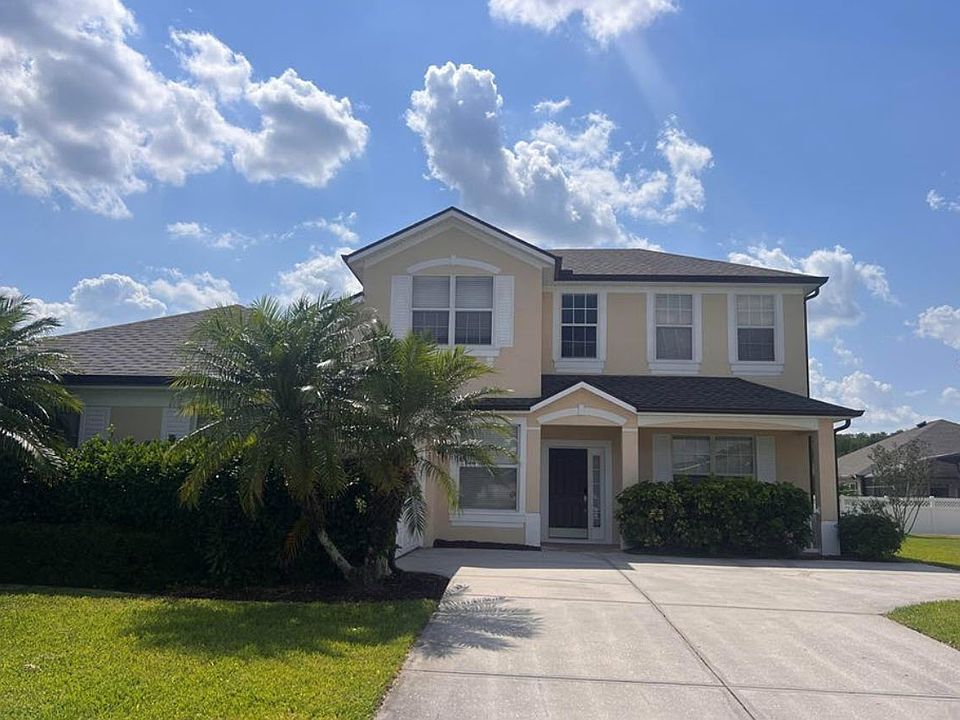 Front view of the home with double garage and elegant palm trees.