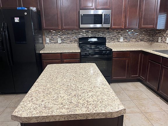 Kitchen with refrigerator, gas stove and new over the range microwave