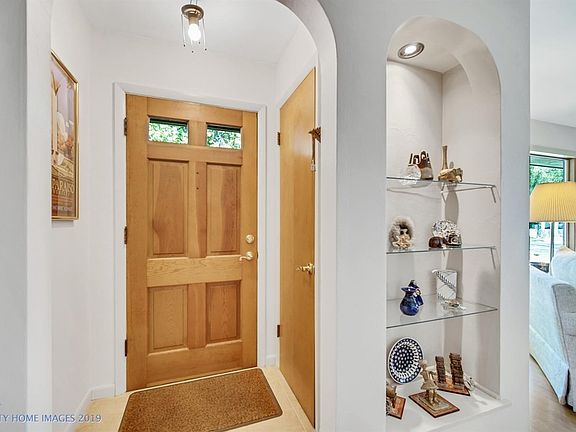 Wall and ceiling construction made of plaster over rock-lath offers excellent sound suppression between rooms and floors. Arched doorways and niche are welcoming accents. New porcelain tile flooring in foyer leads to back door.