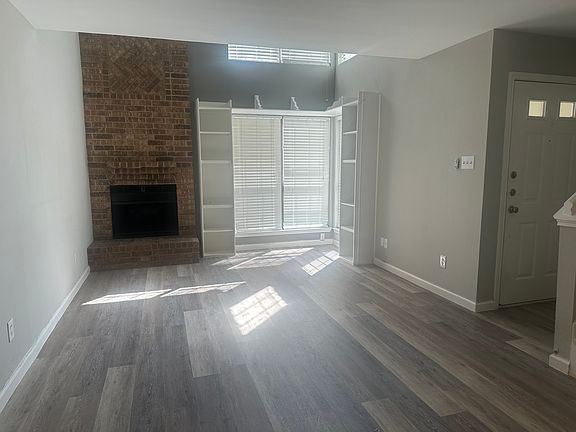 Living room has shelves and fireplace