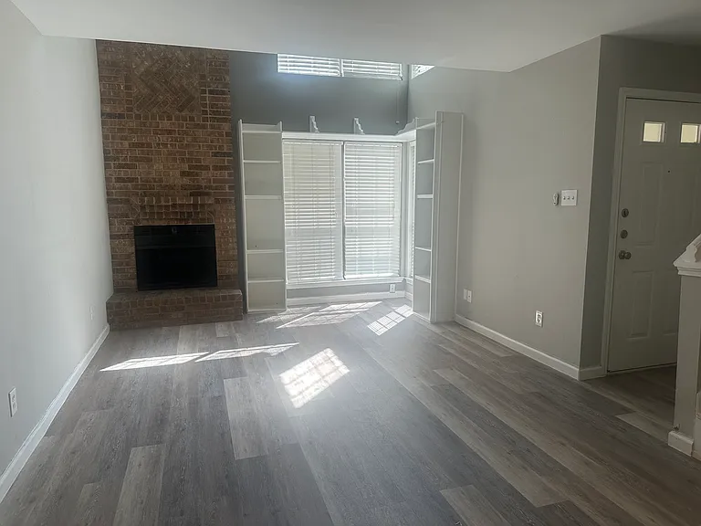 Living room has shelves and fireplace