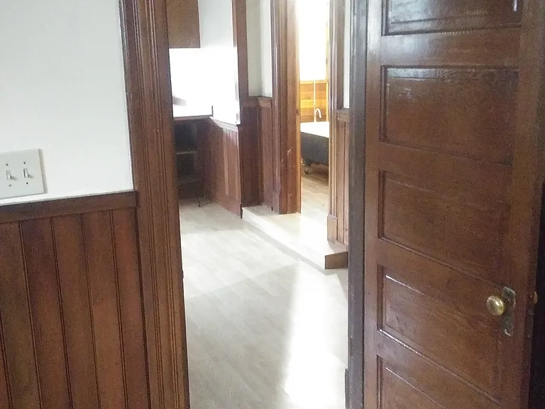 Looking from Bedroom into Living Room with a Peek into the Bathroom with Clawfoot Tub