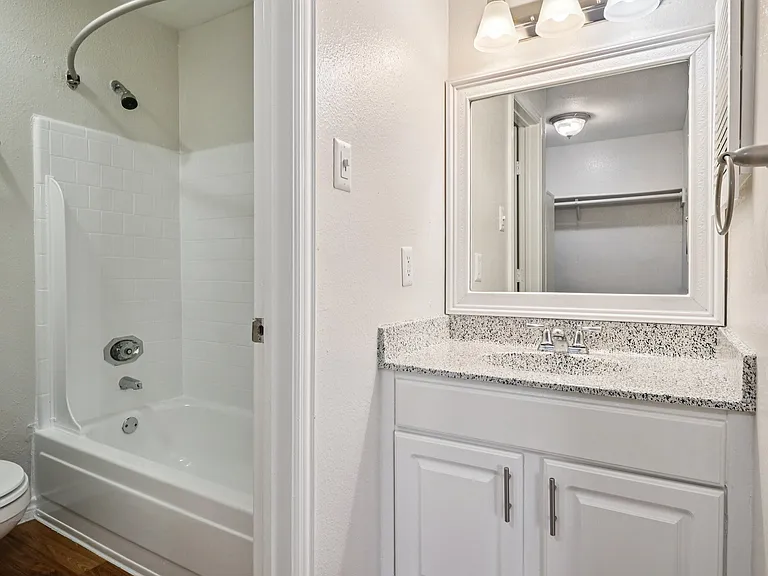Modern bathroom with sleek countertop, white vanity, and pristine bathtub in a bright space. Modern bathroom with sleek countertop, white vanity, and pristine bathtub in a bright space.