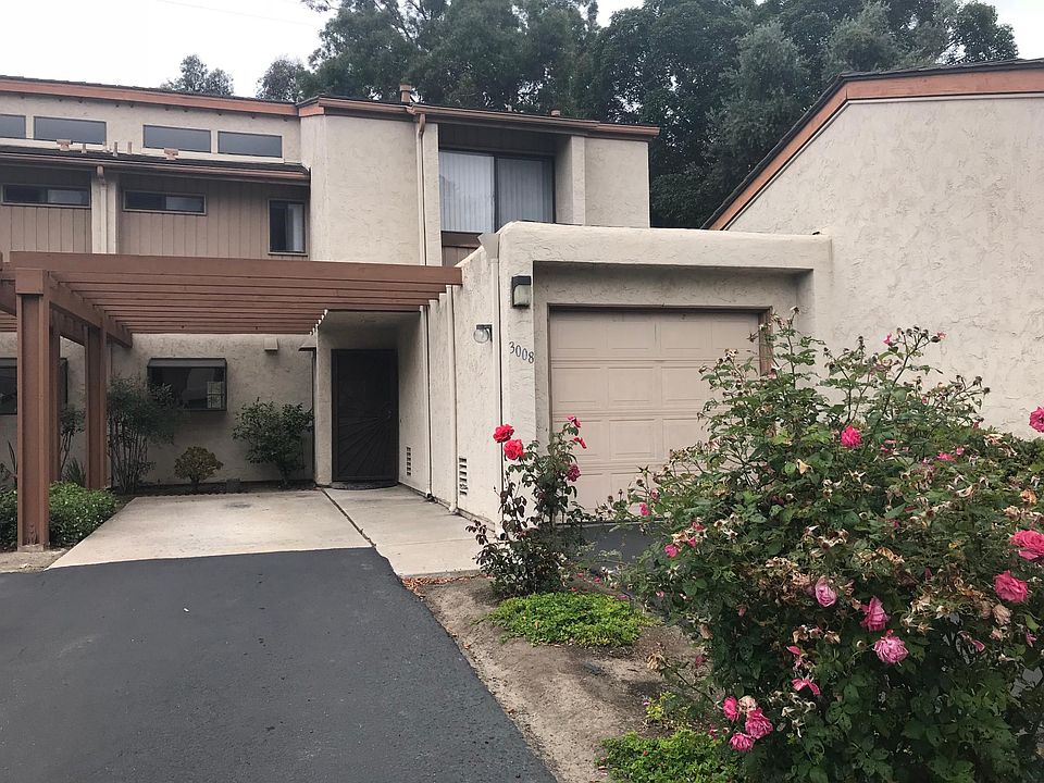 Front of condo with garage and carport