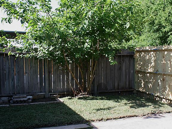 Back patio with nice tree and  greenbelt outside the partially fence area.