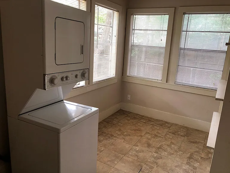 Sunroom/office/storage area, with shelving along one wall and washer/dryer