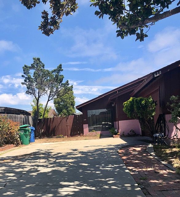 Large driveway with large Magnolia Tree for shade. Gate to backyard.