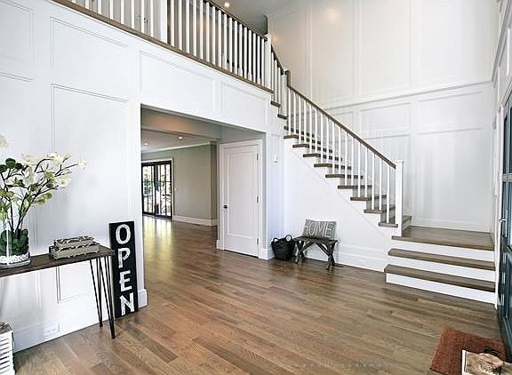 Two story grand foyer with custom wainscoting.