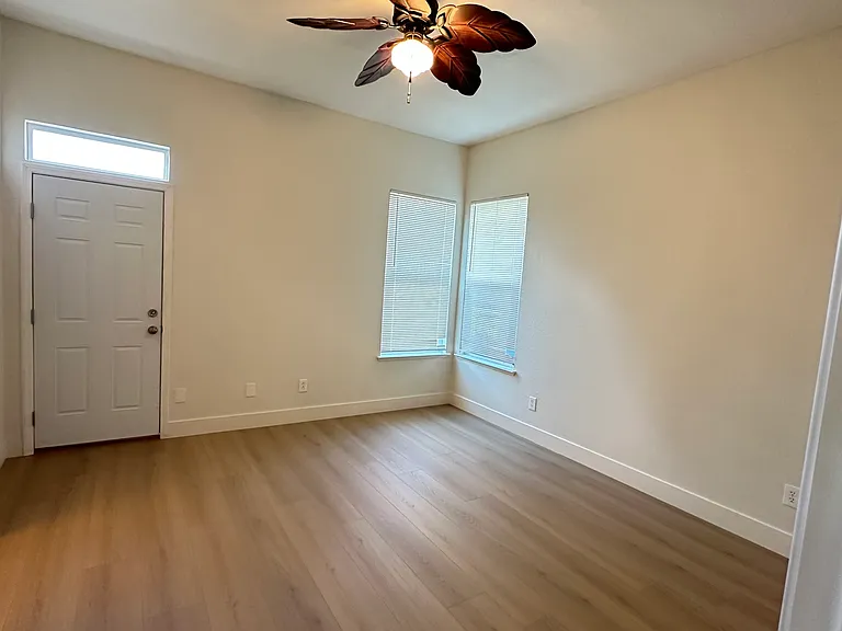 Master bedroom with door access to the back yard and windows