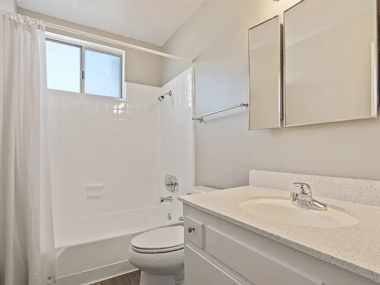 Bathroom with tub and shower combo, single vanity, quartz countertops, wood-style flooring