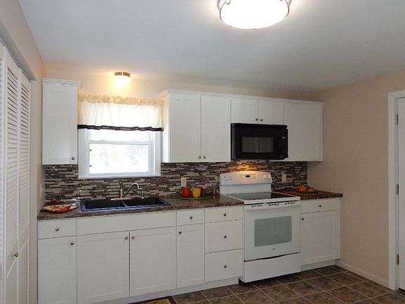 Brand new cabinets, countertops, ceramic tile floor, sink, stove, refrigerator and microwave. The new back splash really makes this kitchen pop.