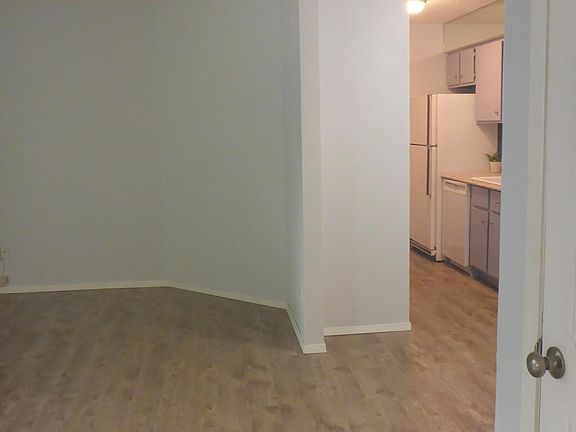 Corner view of living room with kitchen and dining room to the right.