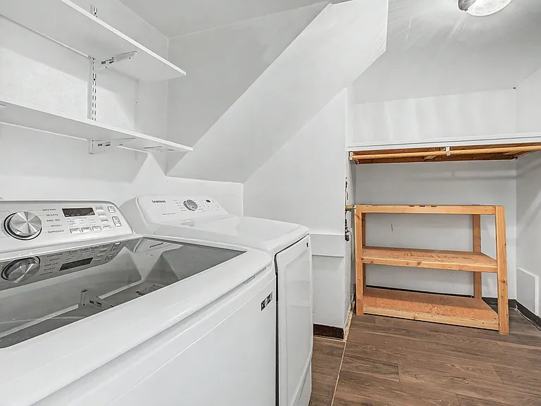Laundry room with almost new large washer and dryer. Extra storage space in the corner.