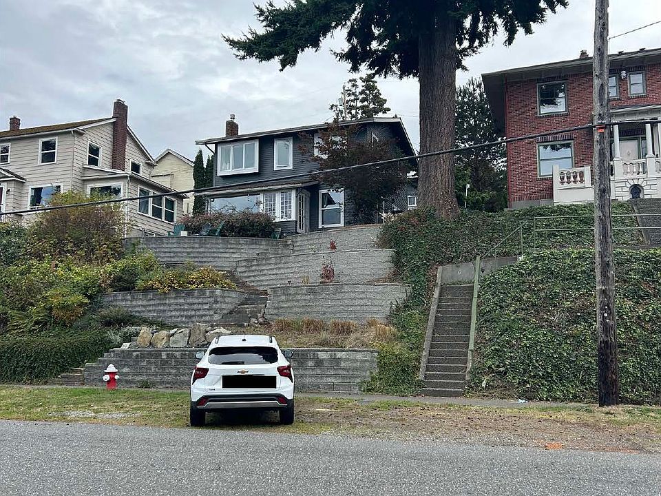 Front view of 412 N State, grey and white center building with steps and terraced garden
