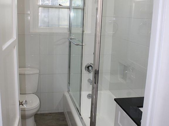 1st bathroom, tub/shower and window, tile looks like wood