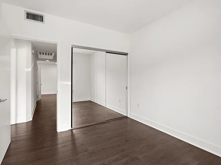 Bedroom with Large Mirrored Closet and Vinyl Flooring