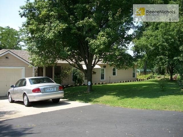 beautiful ranch style home setting on almost an acre of landscap