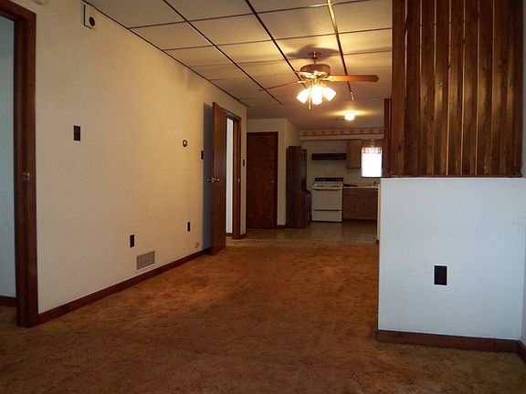 The living room has wall to wall carpeting and overhead lighting