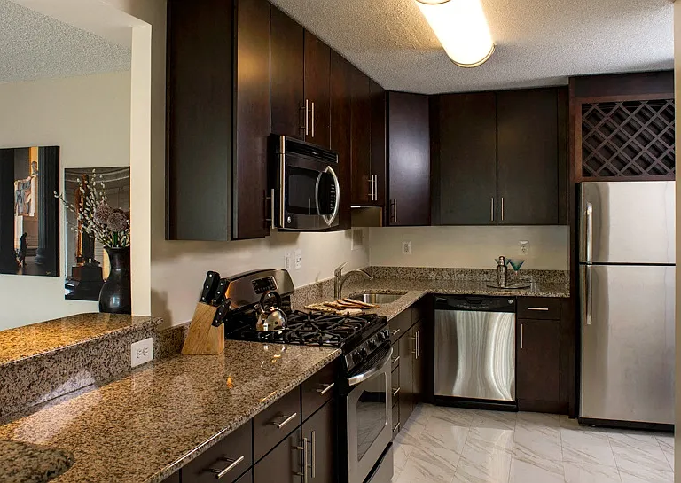Renovated kitchens with stainless steel appliances, dark cherry cabinets and granite counters