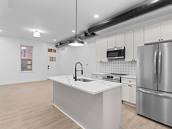 Brand new kitchen with quartz island and stainless steel appliances