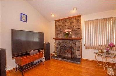 Hardwood flooring in living room with stunning fireplace.