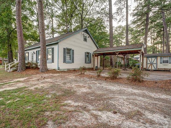 Outside you'll find the oversized deck in the rear; fenced yard to left, and carport and storage to right.