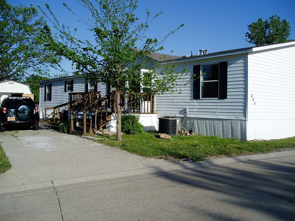 Home showing entrance, driveway and shed