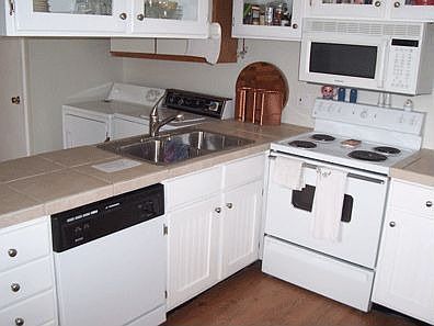 Kitchen with Tile Countertops, Stainless Steel Sink and PERGO Floors
