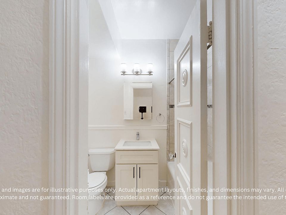 A well-lit bathroom featuring a sink, mirror, and toilet with neutral walls and tiled flooring.