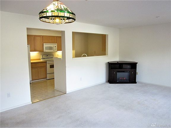 Looking from the dining room to the kitchen and fireplace.