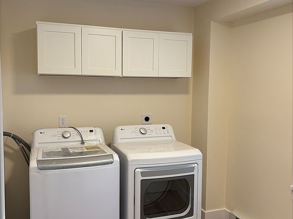 Large laundry room with cabinet storage and large storage closets.