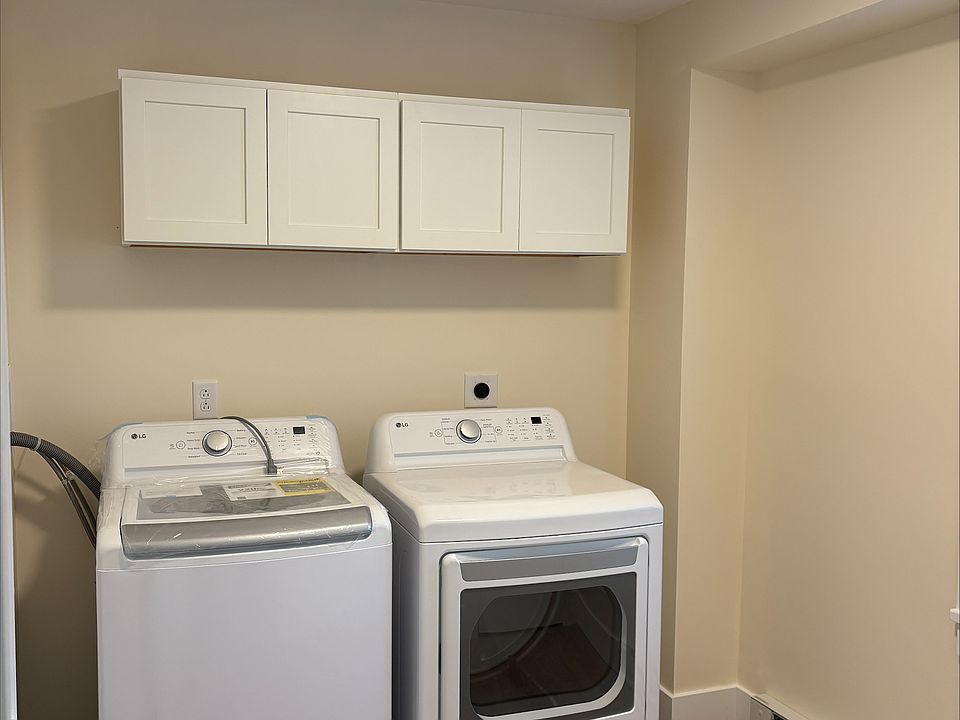 Large laundry room with cabinet storage and large storage closets.