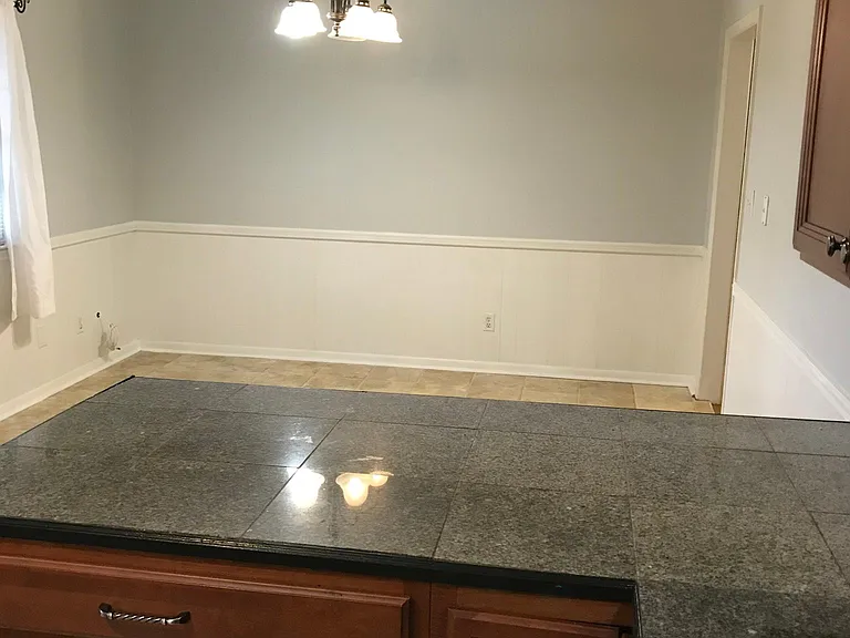 From kitchen looking into eating area. Granite to be replaced with newer granite model