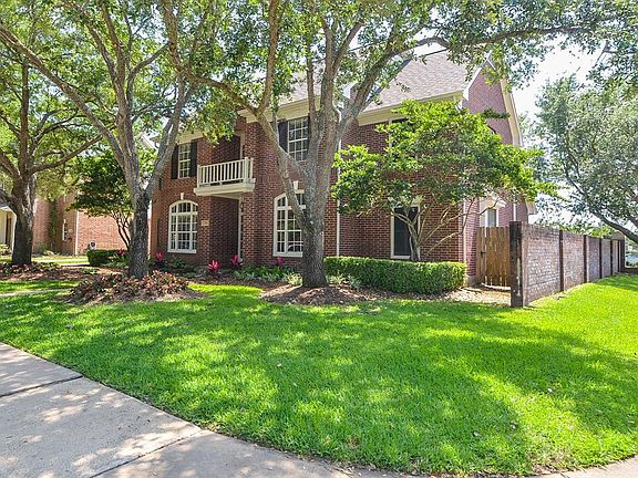 View from corner. Brick fence on side and backyard