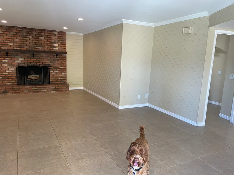 Family room with wood burning fireplace and French doors out to the patio/ pool area