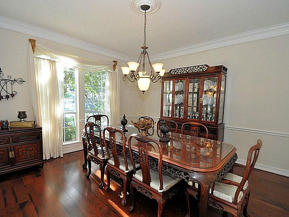Formal dining has wood floors, updated lighting with ceiling medallion and extended trim work
