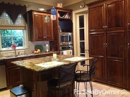 Bright kitchen
						:
						Ash wood stained custom cabinets of varying heights. Lots of storage.