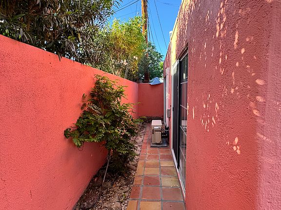 Private side yard with new Saltillo tile and air conditioner condenser/compressor unit that serves 2 indoor evaporator units