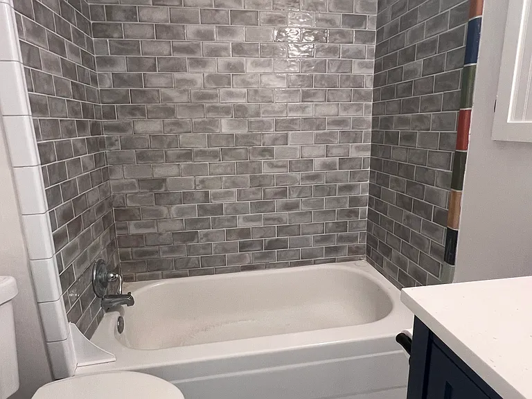 Updated bathroom is freshly painted with new flooring and ceramic tile