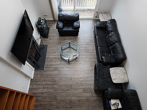 View of Living Room from Second Floor Window - Shows Two Coffee Tables & Balcony