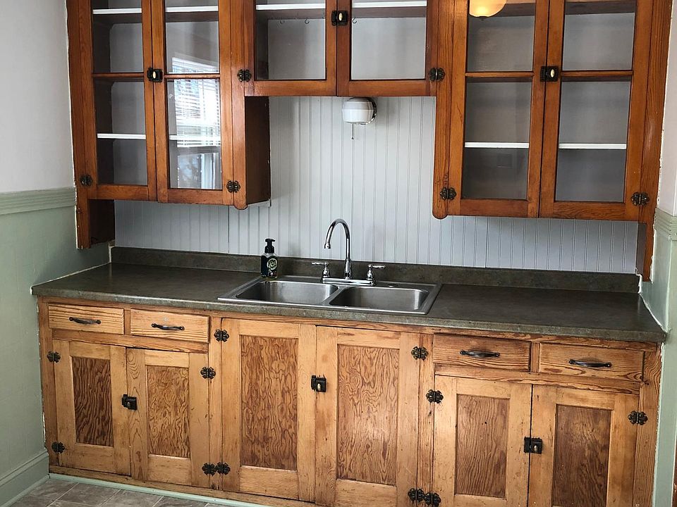 Kitchen with original wood cabinets, new faucet, backsplash, vinyl flooring and paint