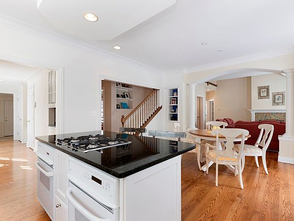 At the heart of the home, this gourmet kitchen is awash in natural light and gleams with black grani