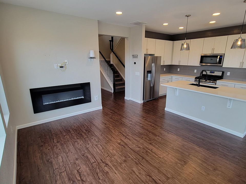 Open concept living and kitchen space with fireplace. Wireless router and smart thermostat on wall included