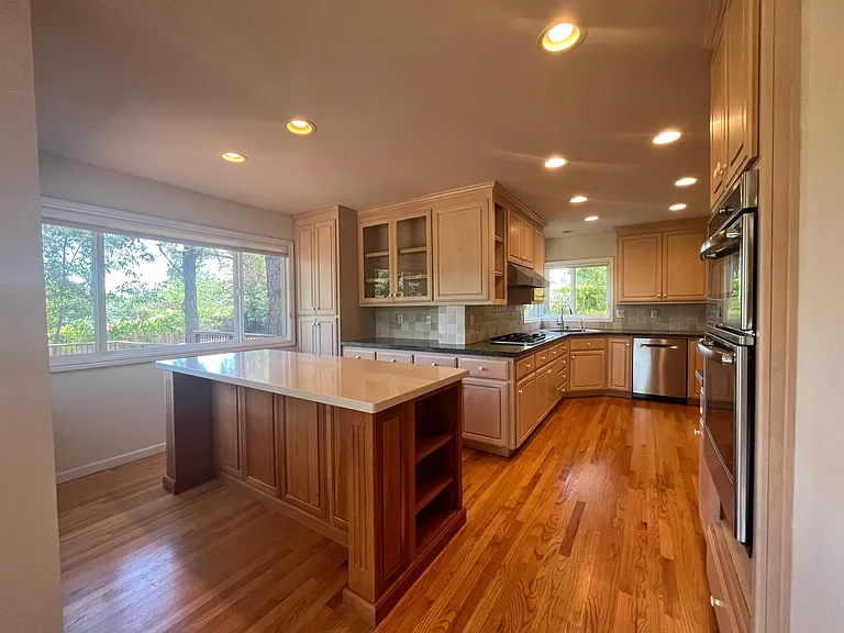 Wonderful gourmet kitchen is equipped with stainless steel appliances, quartz countertop, a lengthy island and soft-close cabinetry.