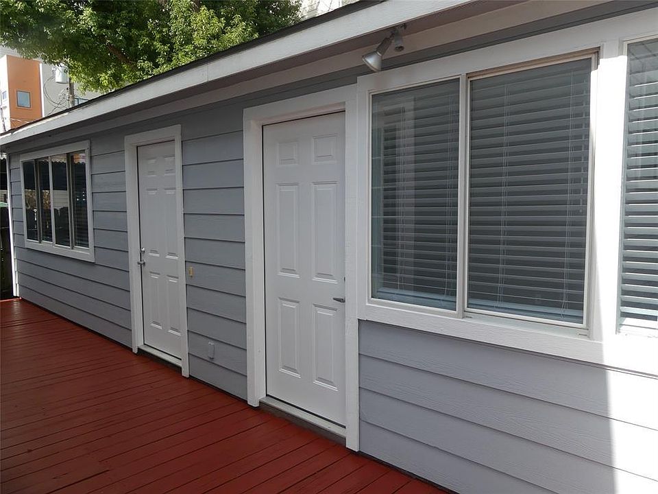 View of the deck and front of the apartment. Door on the right leads to the living room and kitchen area, door on the left leads to one of the bedrooms.
